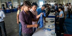 काठमाडौँमा बन्द सत्रका लागि प्रतिनिधिहरूलाई परिचयपत्र वितरण गर्दै कर्मचारी र सहभागीहरू भीडभाड भएको हलमा देखिएका छन्