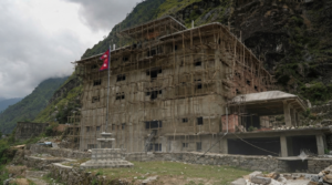 रसुवागढीस्थित निर्माणाधीन एकीकृत भन्सार भवनमा बाँसको मचान लगाएर काम गर्दै श्रमिक
