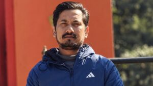 निलो ज्याकेट लगाएका एक पुरुष बाहिरी स्थानमा उभिएको दृश्य